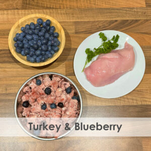 A bowl of raw dog food with Turkey and Blueberries