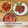 A bowl of raw dog food with beef and strawberries